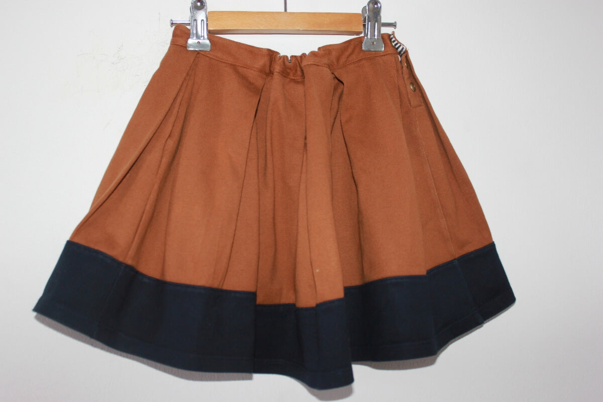 tweedehands katoenen lichtbruine rok met donkerblauwe rand aan de onderkant van petit bateau in maat 110-116
