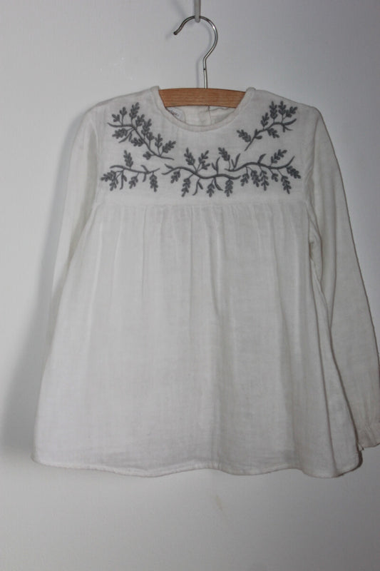 Preloved katoenen witte blouse met grijs geborduurde bloemen op de borst en lange mouwen van Fina Ejerique in maat 116 
