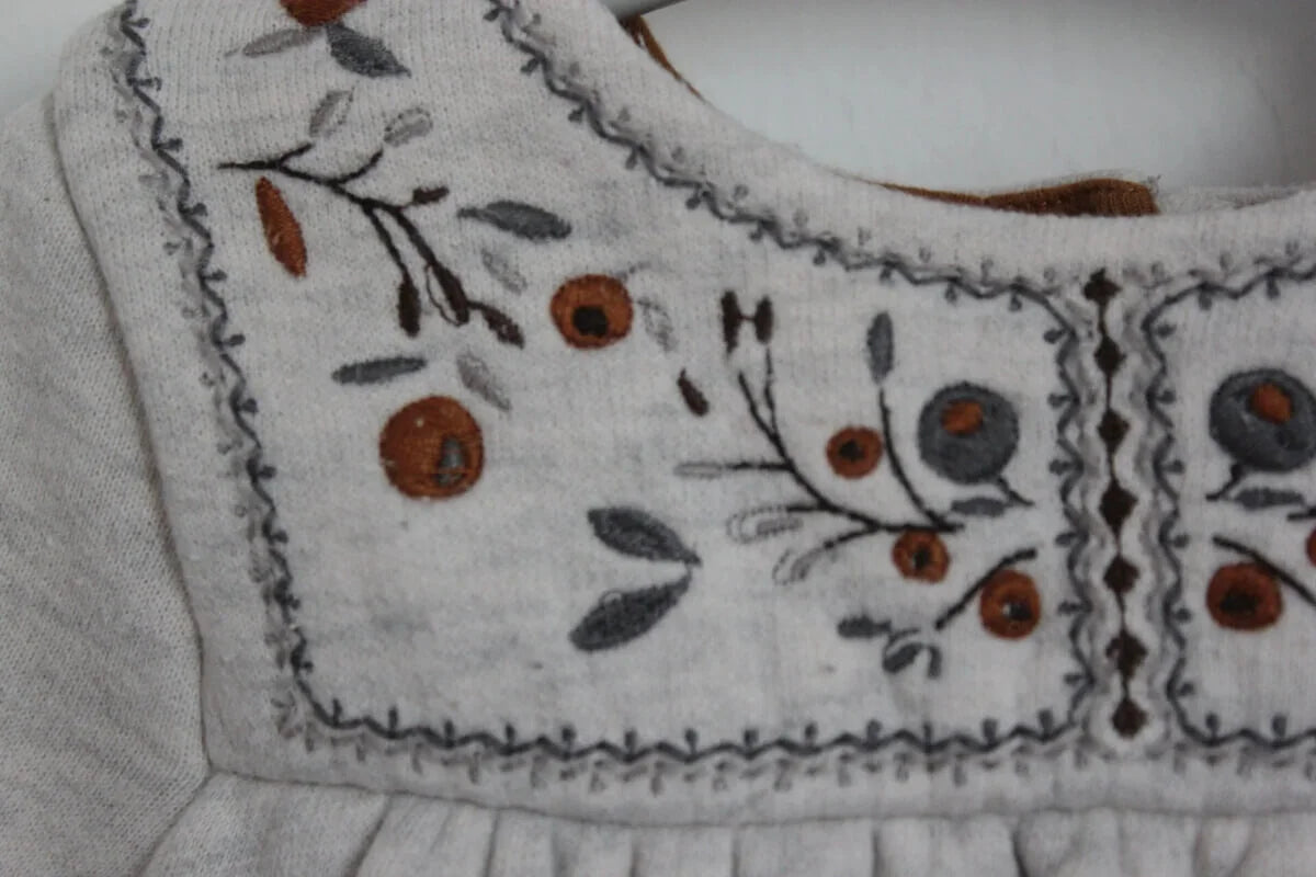 preloved katoenen lichtgrijze jurk met geborduurde bloemen op de borst van petit bateau in maat 74 voor een baby meisje